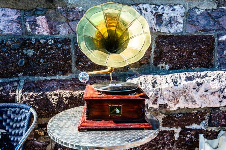 Vintage gramophone on a metal café table against a stone wall